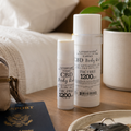 Two bottles of Lavineau CBD Body Lotion on a table with a passport, keys, and a plant in the background.